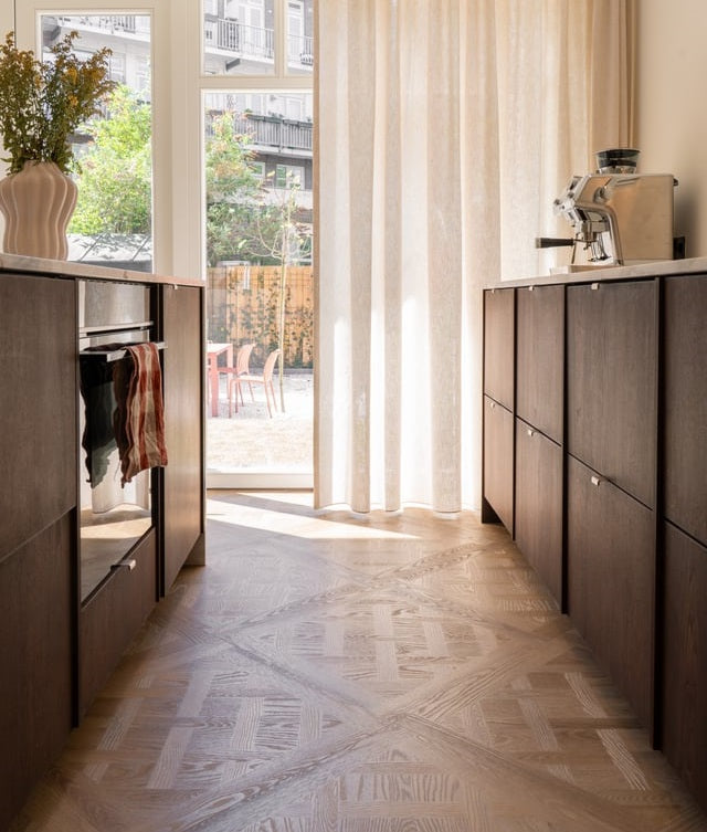 Keuken met tuindeuren, linnen gordijnen en een Versailles-vloer in het zonlicht