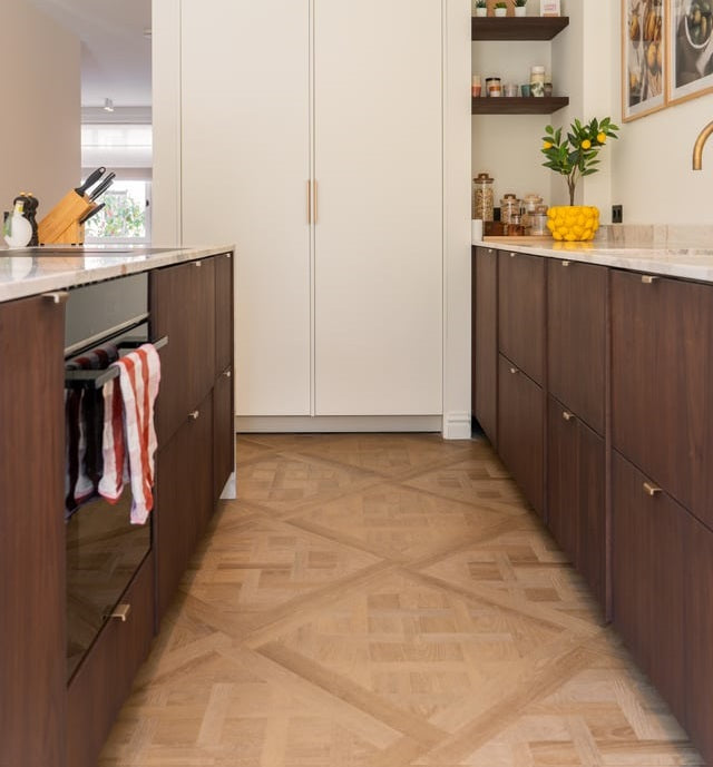 Keuken met donkere kasten, een witte voorraadkast en een Versailles-vloer